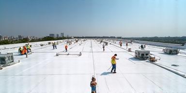 Panoramic view of a large commercial roof project in progress.